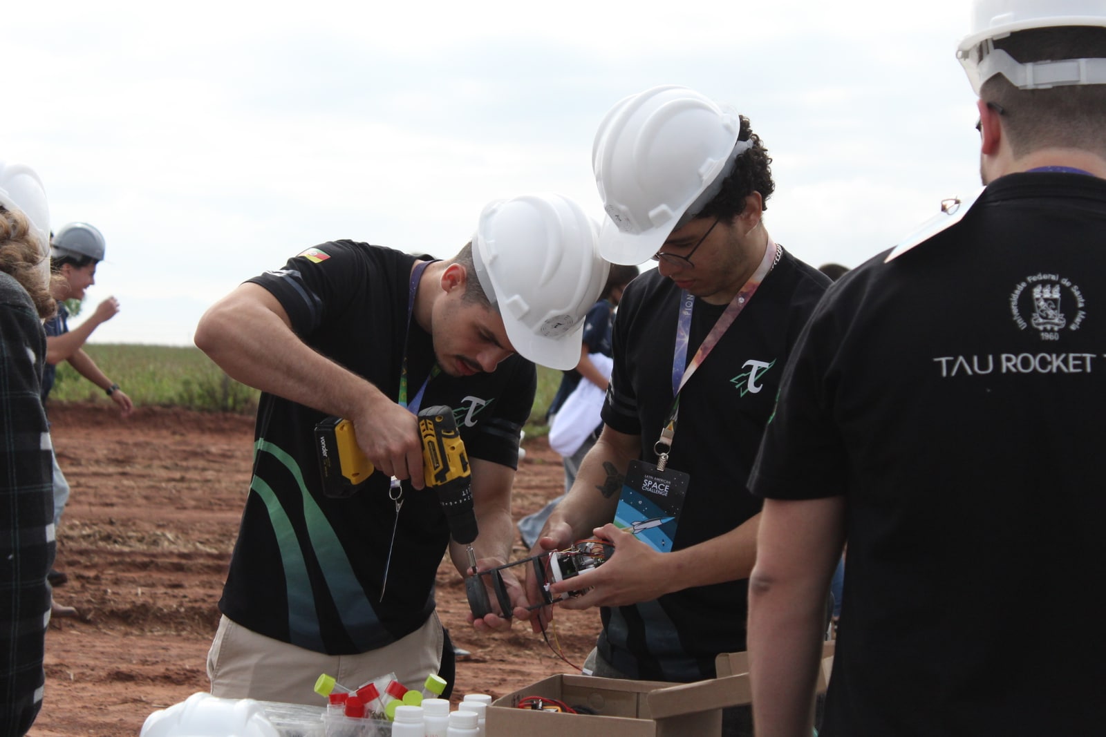 Membros da equipe montando e testando a carga eletrônica em campo